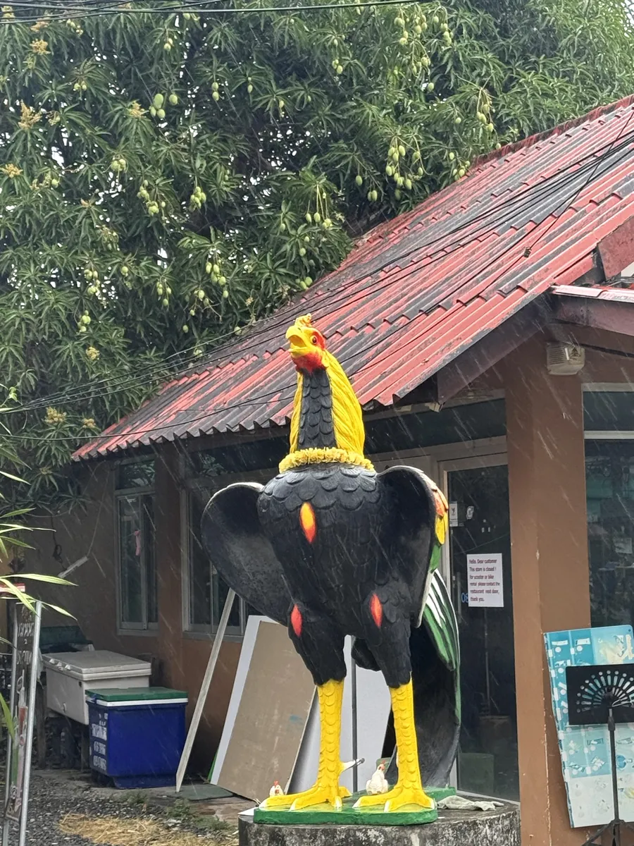 A giant rooster statue outside a building
